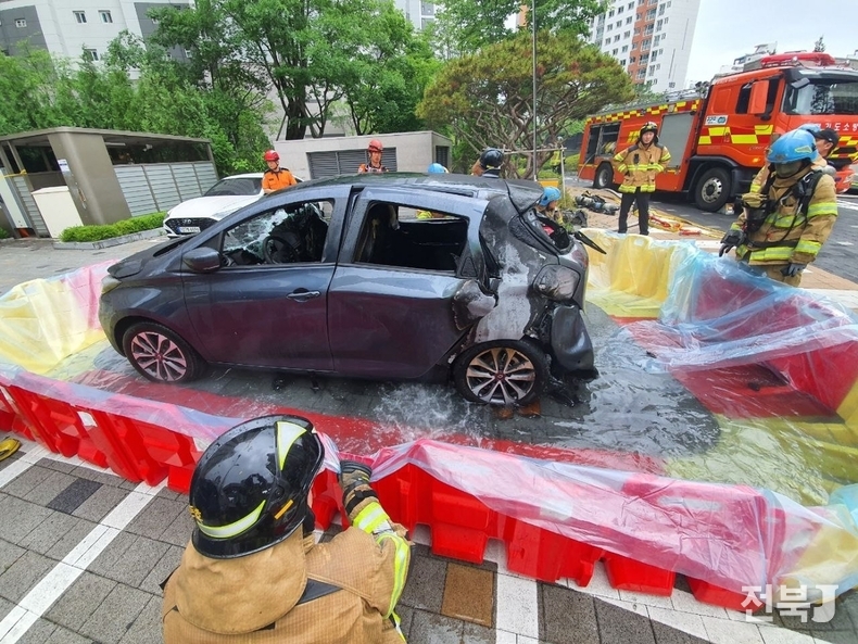 25일 오전 7시55분께 경기도 하남시 신장동의 한 아파트에서 불이 난 차량을 소방당국이 불이 난 차량을 지상으로 견인한 뒤, 이동 조립식 소화 수조 등을 사용해 진압 작업을 이어가고 있는 모습.(출처=경기도소방재난본부)